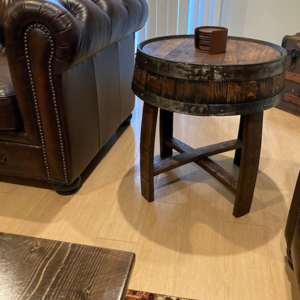 Rustic wooden barrel side table beside a leather sofa, showcasing a unique, vintage aesthetic. Perfect for adding character to cozy, chic spaces. #HomeDecor #VintageFurniture #RusticTable #InteriorDesign