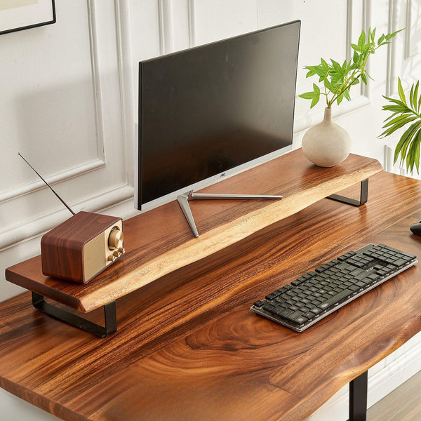 Minimalistic home office space with sleek computer monitor on wooden stand, retro radio, verdant plants, and stylish keyboard.